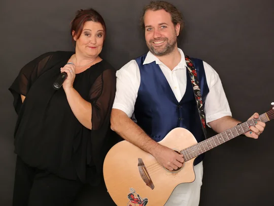 Eine Frau mit Mikrofon und ein Mann mit Gitarre