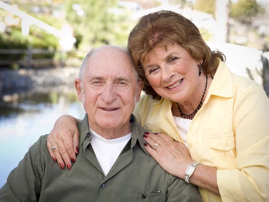 ein Senior und eine Seniorin eng nebeneinander