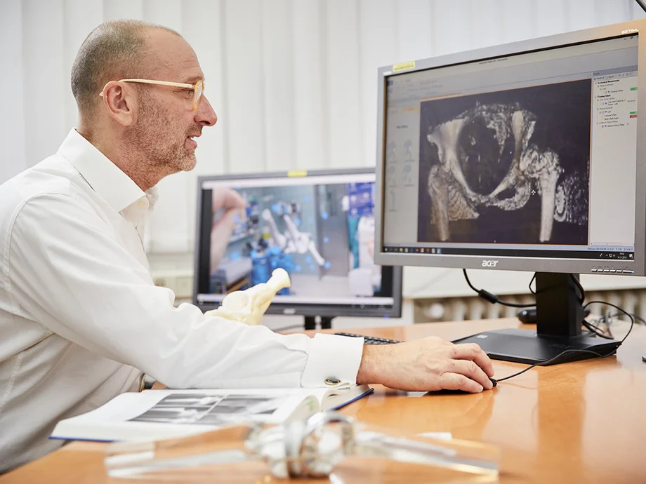 Orthopäde am Computer bei der Diagnostik eines CT-Bildes