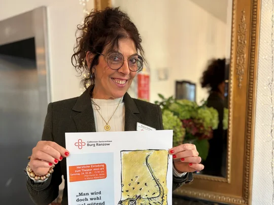 Frau hält Plakat in die Kamera