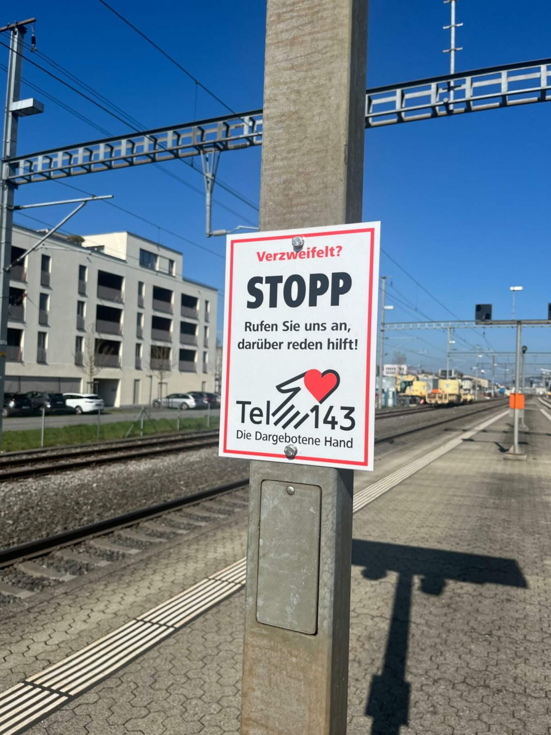 Schild einer Telefonseelsorge zur Prävention von Schienensuizid